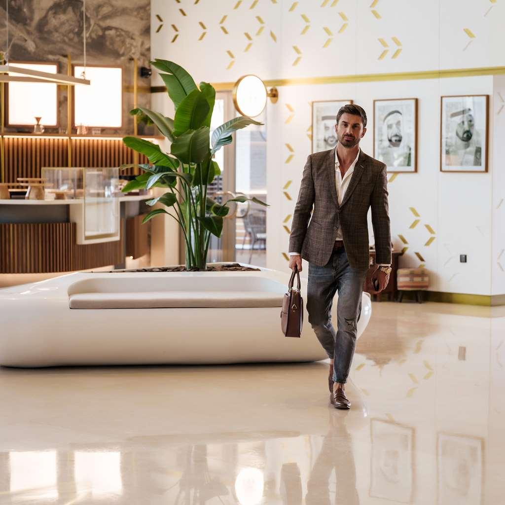 ホテル The First Collection Dubai Business Bay インテリア 写真 A man walking through a lobby